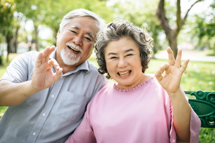 Elderly male and female expressing their satisfaction and happiness after dental implant procedure.