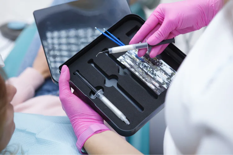 Dentist providing instructions on how to use a teeth whitening kit, including applying whitening gel, recommended duration, and frequency.
