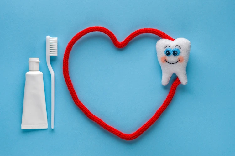 Toothpaste and toothbrush beside soft toys of happy tooth and heart.