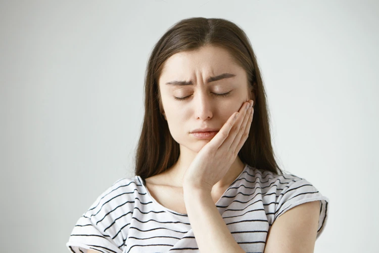 Lady experiencing pain and discomfort in her lower left jaw due to wisdom tooth.
