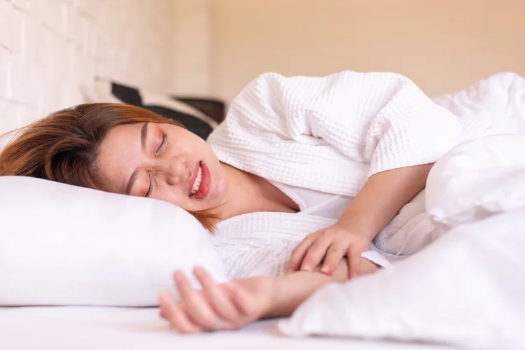 Woman sleeping showing teeth clenching illustrating bruxism or teeth grinding during sleep.