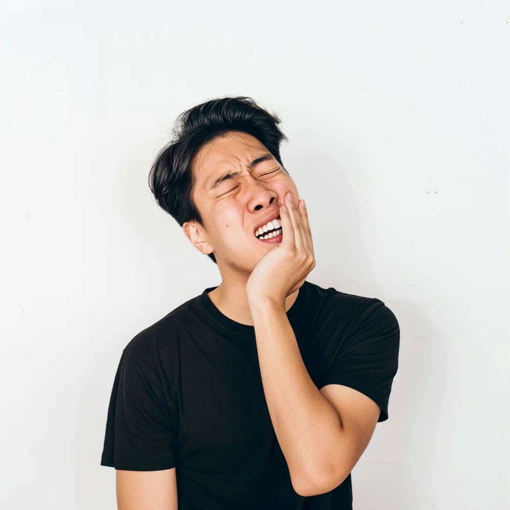 Young asian man experiencing excruciating toothache pain.