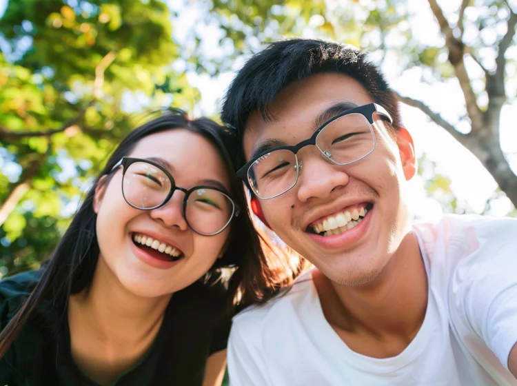 Young Singaporean couples smiling confidently and happily after undergoing Invisalign treatment.
