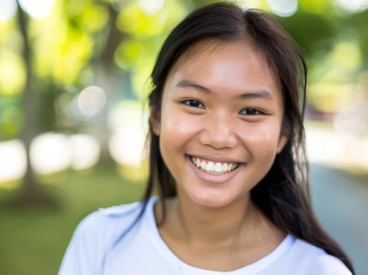 Young Singaporean girl smiling confidently and cheerfully after choosing Invisalign for its aesthetic appearance, comfort, and convenience.